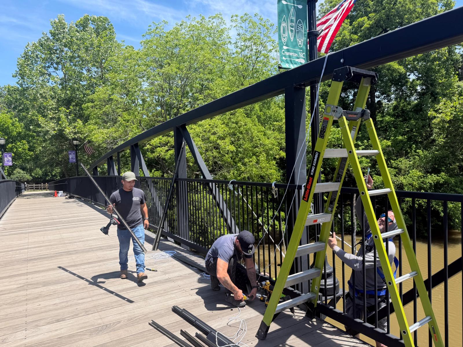 Installer carrying LED track into position along the bridge deck