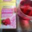 A box of Twinings Cranberry & Raspberry fruit tea next to a glass pitcher of the freshly brewed, vibrant red tea.