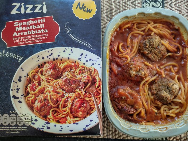 Product review image of the Zizzi Spaghetti Meatball Arrabiata from Tesco, comparing the image on the box to the actual cooked meal in its plastic tray.