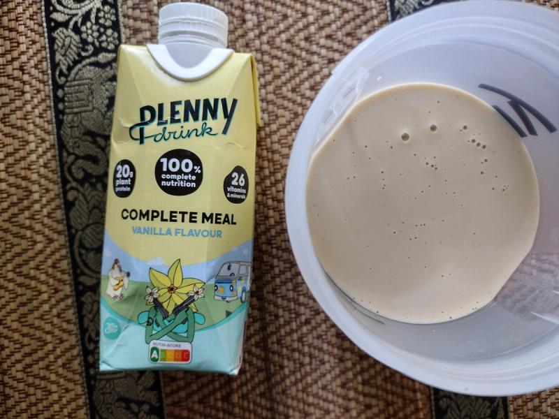 The appearance of the Jimmy Joy Plenny Drink, showing the vanilla packaging and the drink's texture for a product review.