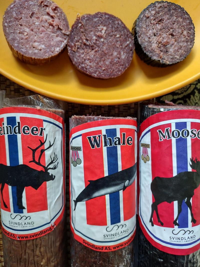 A comparison of three traditional Norwegian cured meats from Svindland Spekemat. Packages and slices of reindeer, minke whale, and moose sausage are displayed