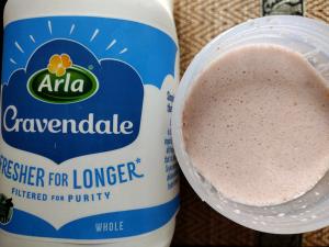 The finished Protein Works Complete 360 Meal shake beside the bottle of Arla Cravendale whole milk used as a mixer in a product review.