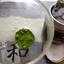 A photo showing the YEDOENSIS pure ceremonial matcha in a clear cup, alongside the tin.