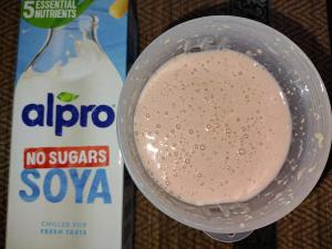 The Sneak Eats strawberry meal replacement shake mixed with Alpro No Sugars Soya milk, showing a thick and creamy consistency next to the product carton.