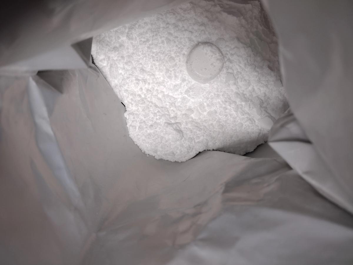 A close-up look inside a 1kg bag of Bulk micronised creatine powder, with the clear scoop visible.