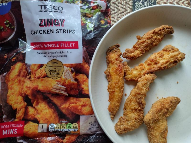 A top-down photo of golden-brown Tesco Zingy Chicken Strips in a bowl, with the 400g packaging shown alongside for a product review.