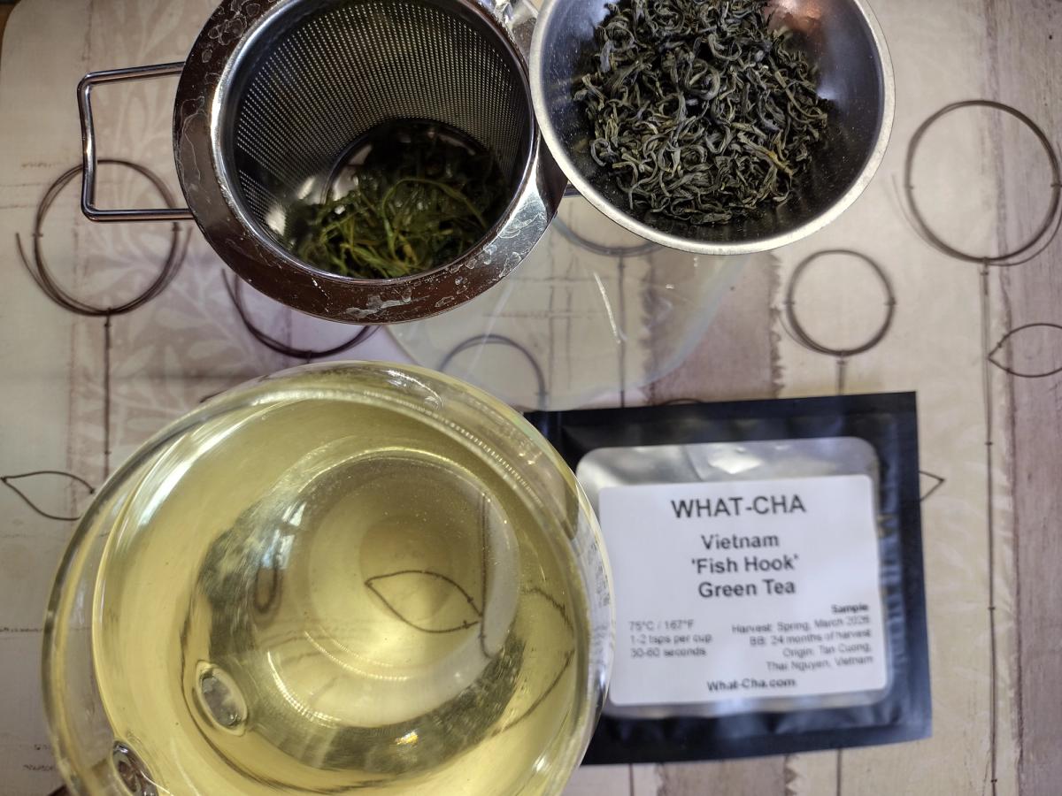 Vietnam Fish Hook green tea from What-Cha with curled dry leaves, brewed leaves and pale yellow-green liquor.
