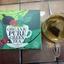 A box of Clipper Organic Pure Green Tea with a glass mug showing the light, yellow-green colour of the brewed tea.