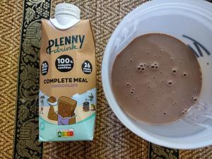 The appearance of the Jimmy Joy Plenny Drink in chocolate flavour, poured from its carton into a cup for a product review.