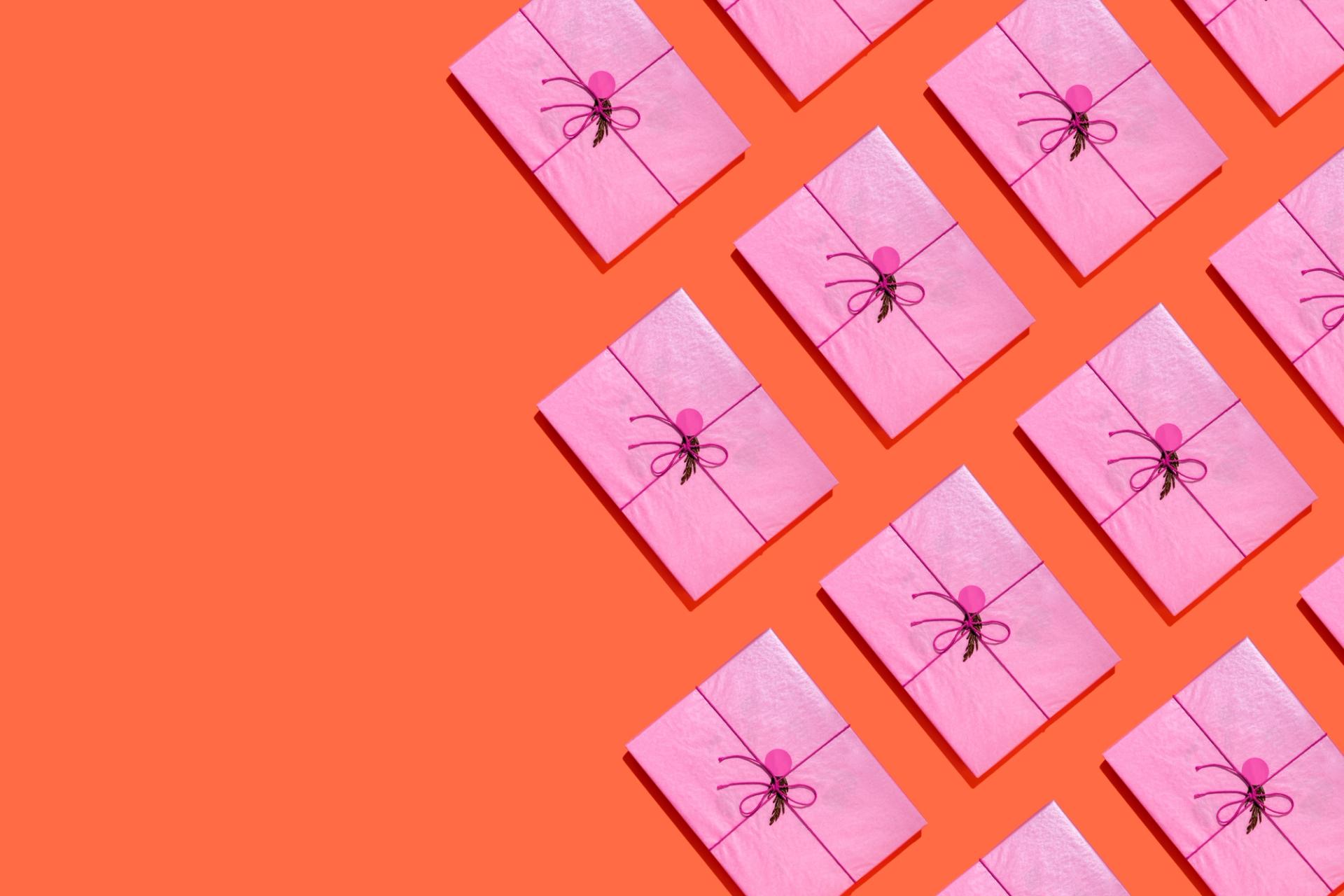 Directly above view of some pink gift boxes on orange background