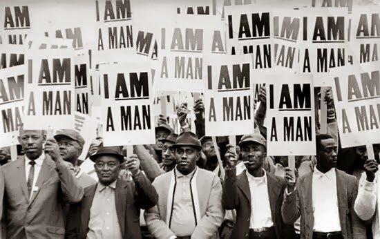 A group of men holding up protest signs.