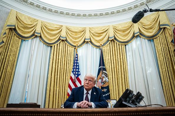 President Donald Trump speaks with reporters and signs executive orders in the Oval Office. (Getty Images/Washington Post)