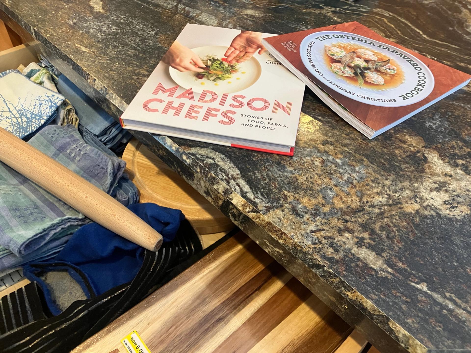Two books on a grey counter in front of an open drawer.