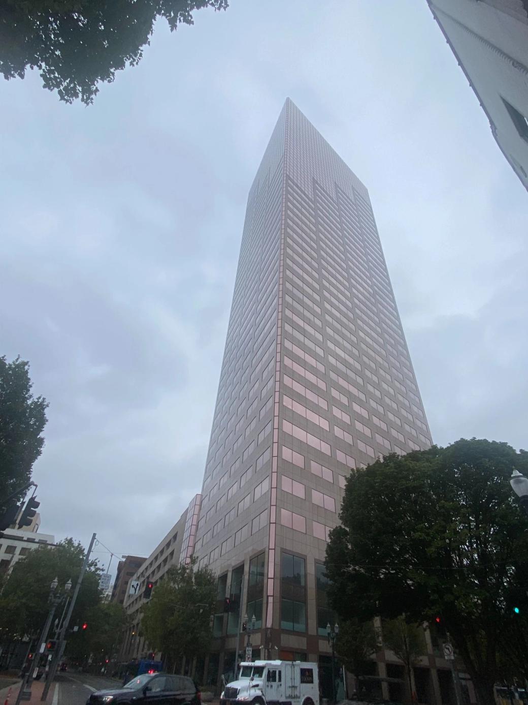 View of tall building in urban area from ground level on a cloudy day