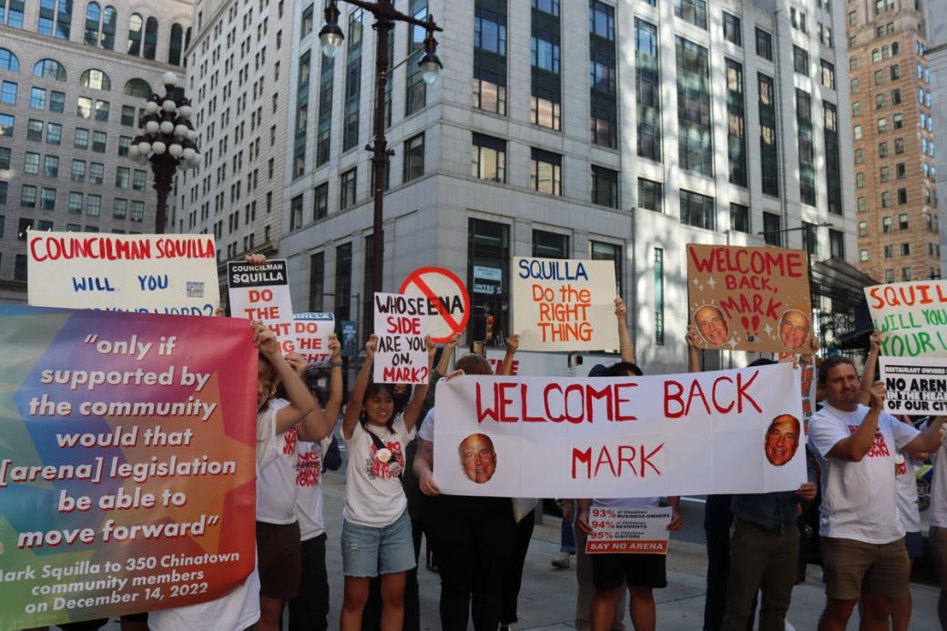Protesters hold up signs about Councilmember Park Squilla