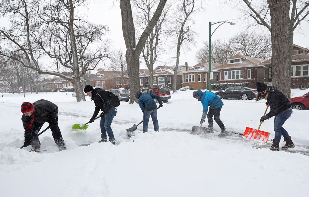 My Block My Hood My City volunteers shovel snow to clear a sidewalk