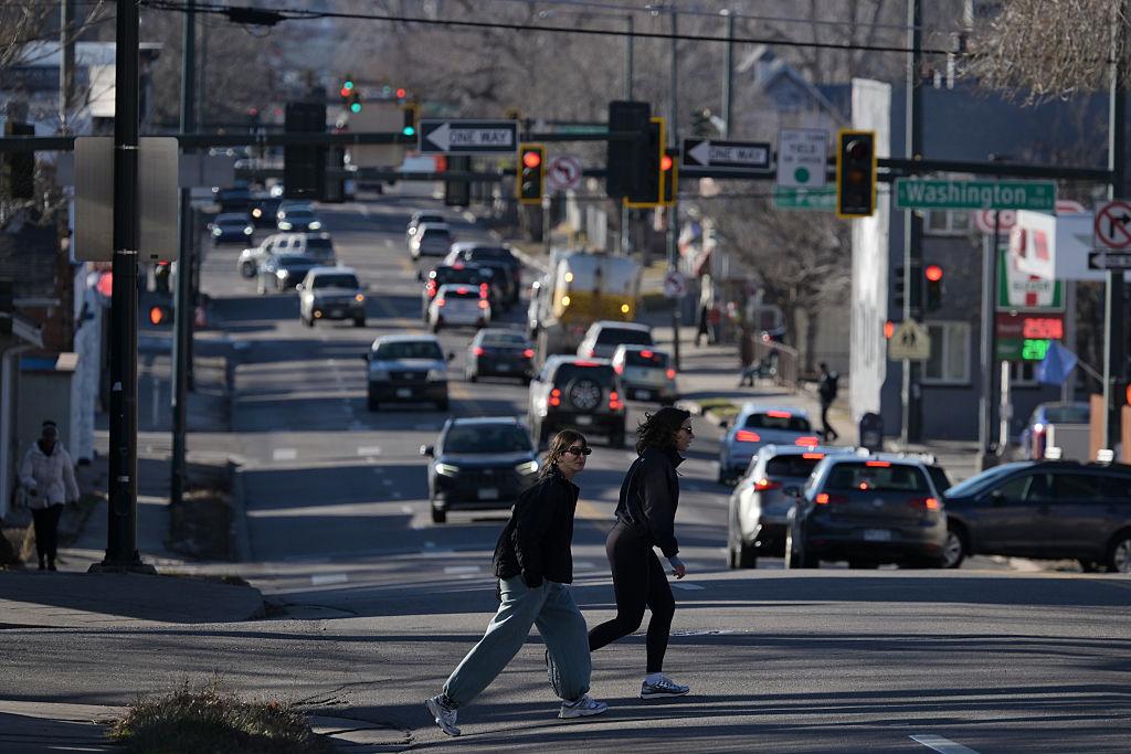 People cross a busy street while looking out for cars