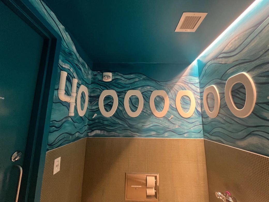 A bathroom with waves painted on the walls and "40,000,000" featured.