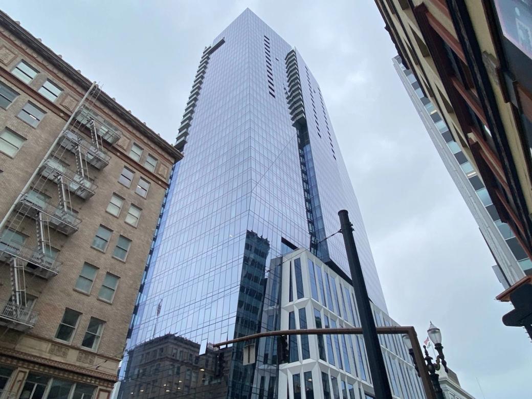 glassy high-rise tower next a brick high-rise