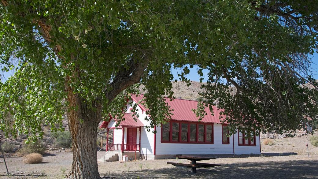 A white single-story building with a red roof.