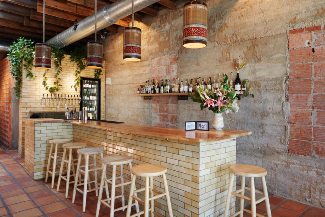 A bar made with white brick and a wooden table top.