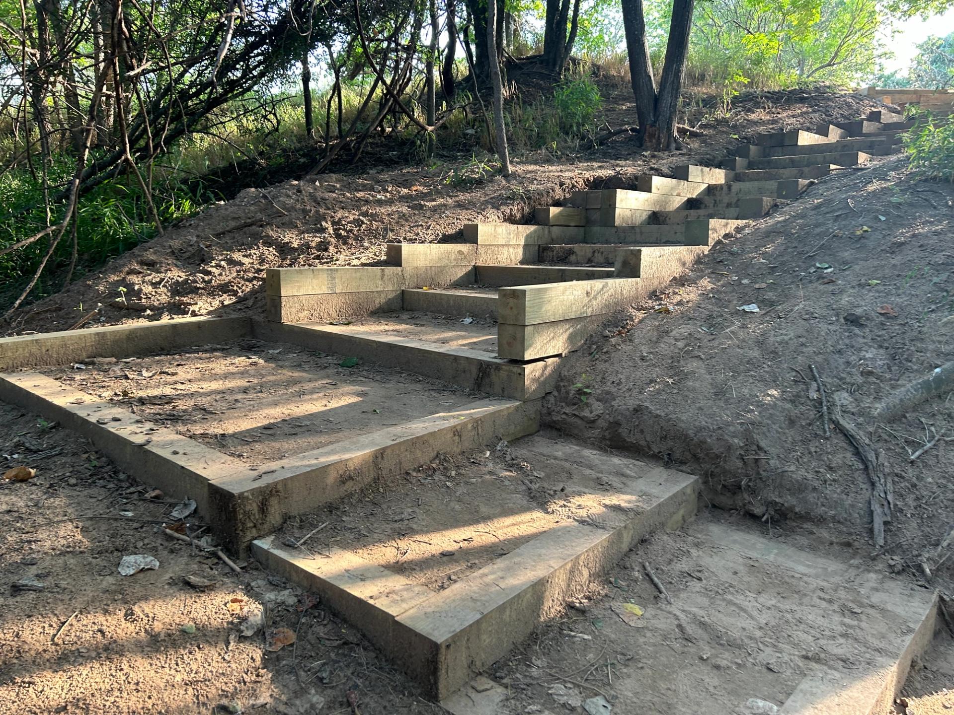A set of stairs on a dirt trail.