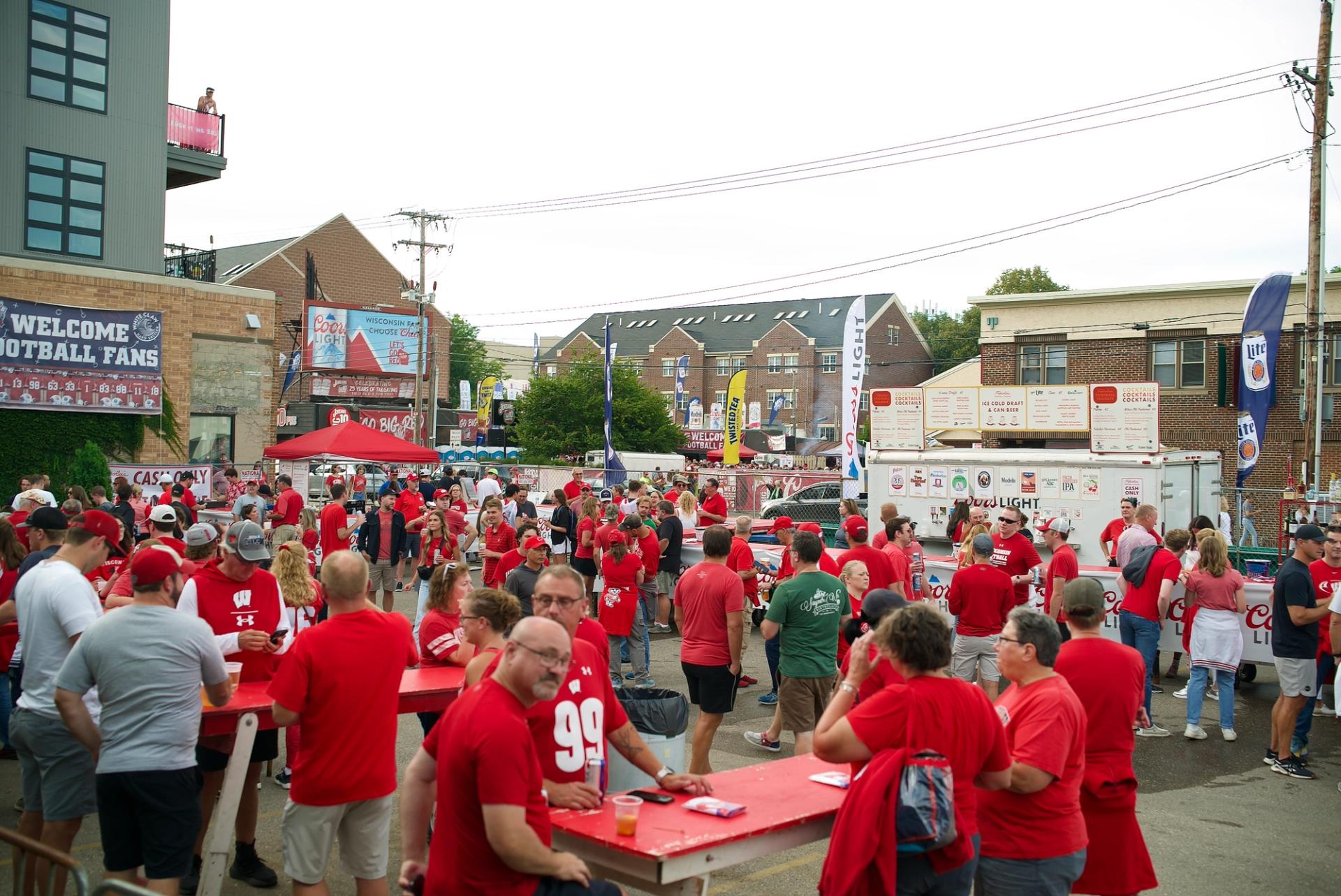 A crowd of people in red gather in a parking lot