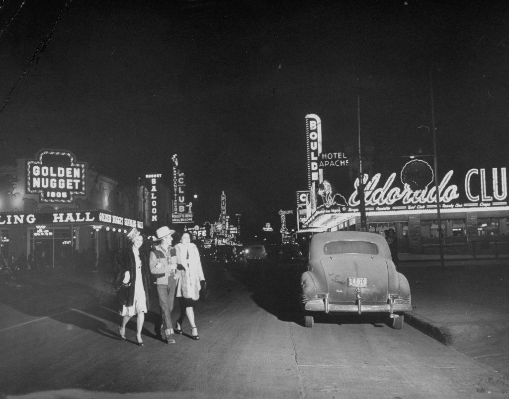 A cowboy and his two ladies stroll through Glitter Gulch circa 1947.