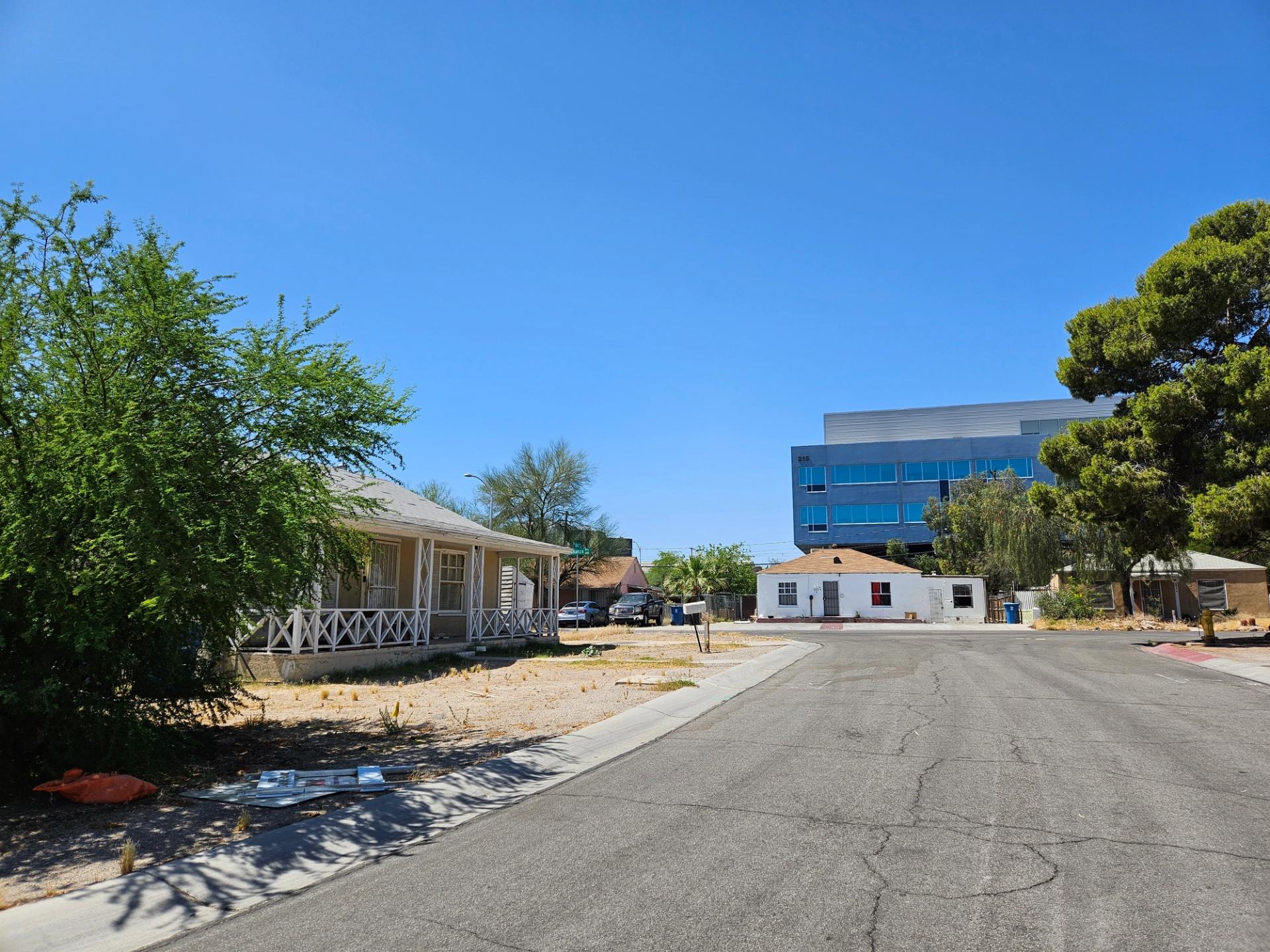 A quiet street with three small houses.