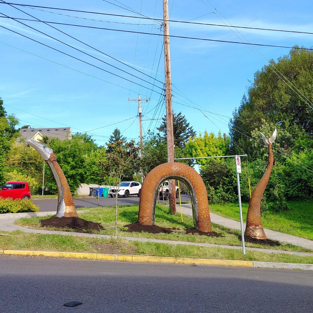 A rusty colored serpent sculpture.