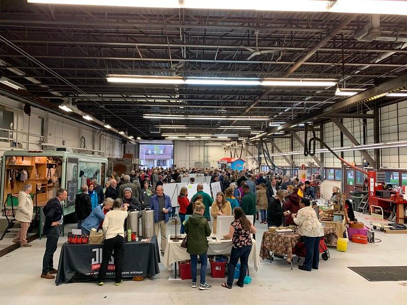 The Madison Public Market during one of its pop-ups. Vendors man tables, and in one case a truck, as people mill about.