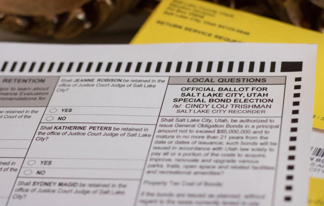 A mail-in ballot for a Salt Lake City special bond election lies in front of a yellow envelope.