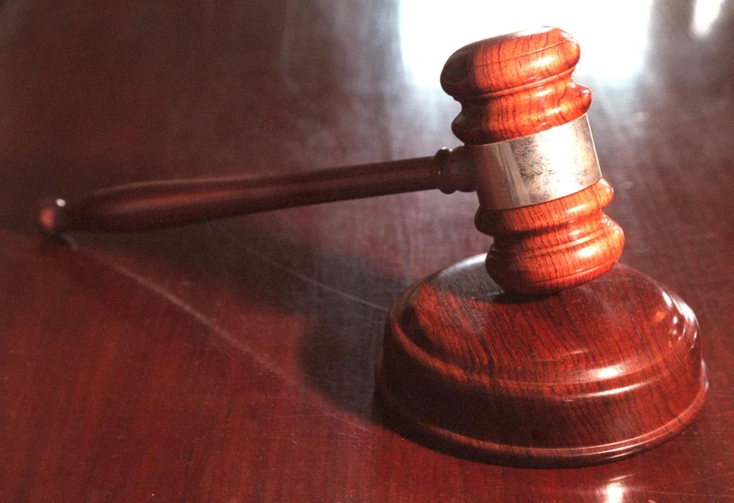 A wooden gavel on a wooden desk