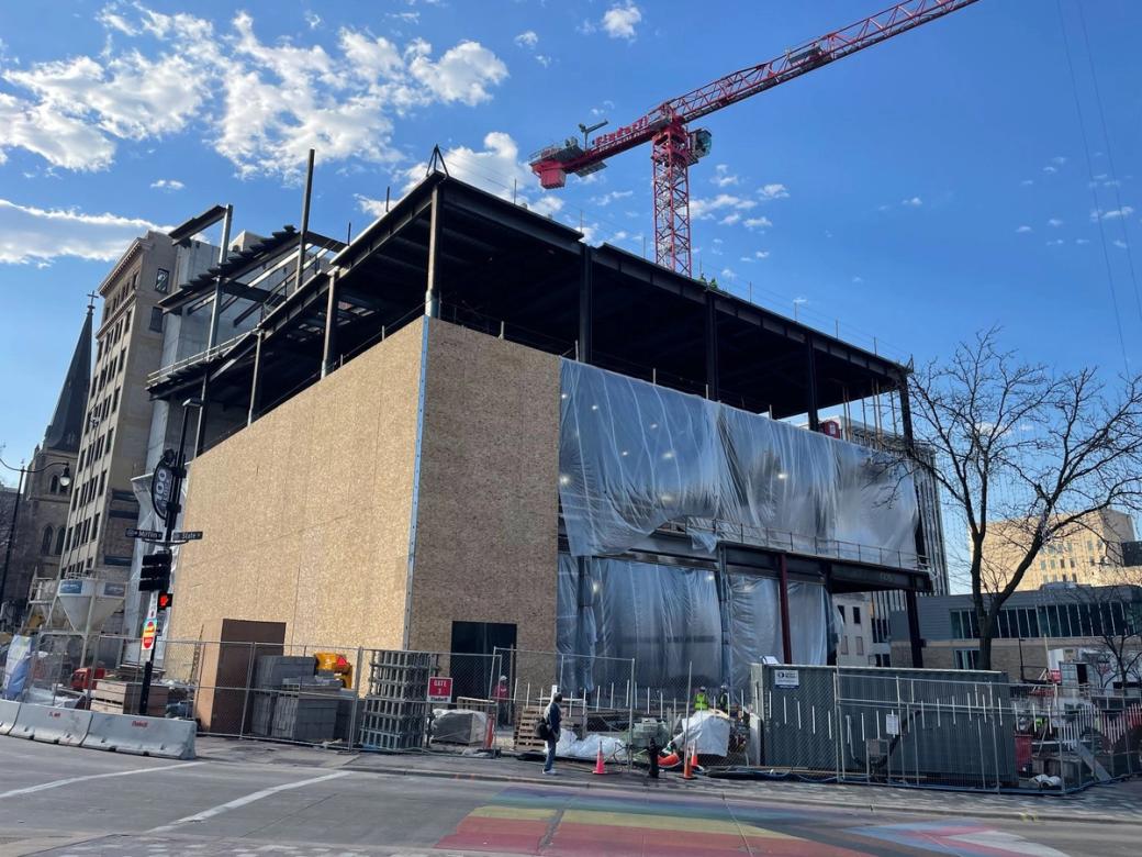 A multi-story building under construction in downtown Madison on a sunny day.