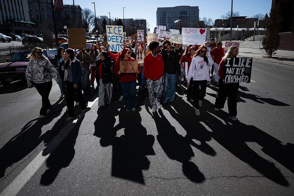 Students march on Lincoln Street carrying signs that say things like “I like my ICE crushed,” “I.C.E. deez nuts” and “Silence sides w/harm.”