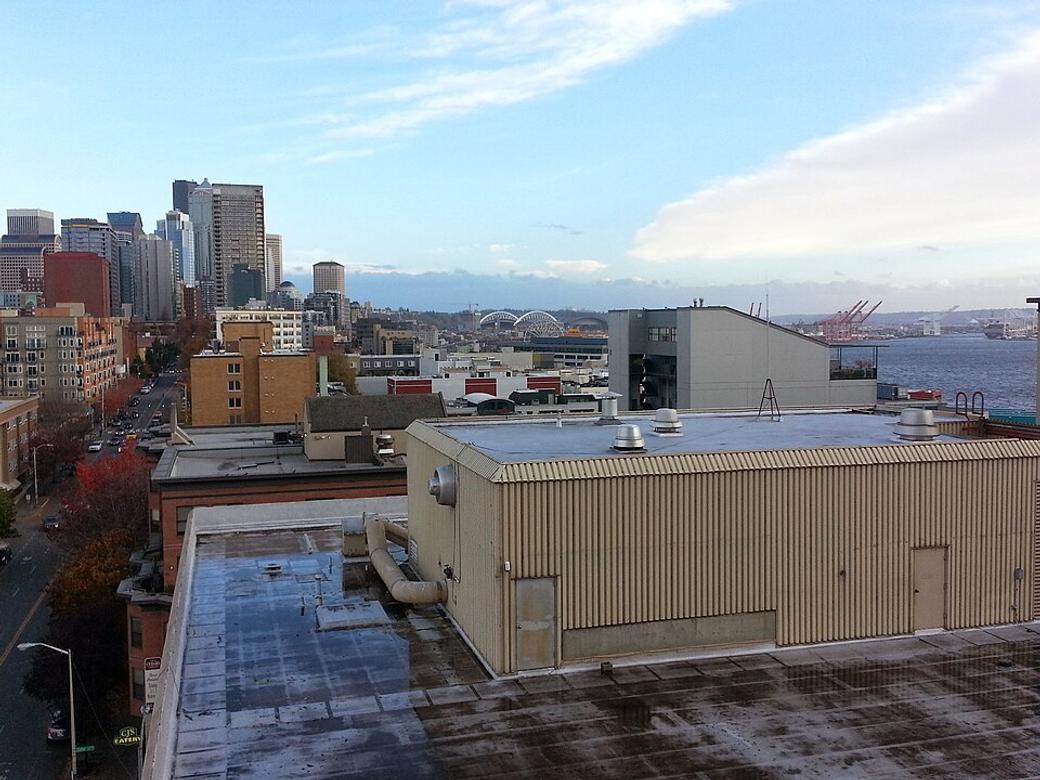 An image of the rooftops of Belltown with Elliot Bay in the distance