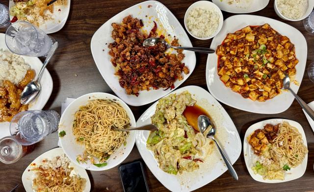 an overhead shot of Chinese noodles, chicken, and rice dishes