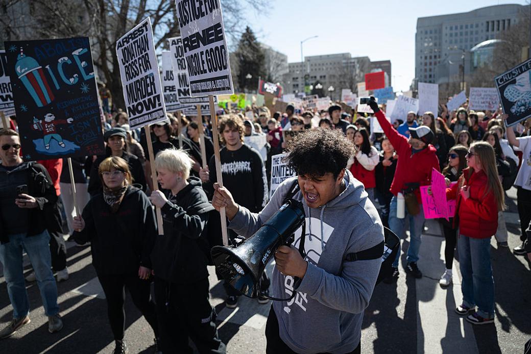 High school students at a protest holding signs and a megaphone