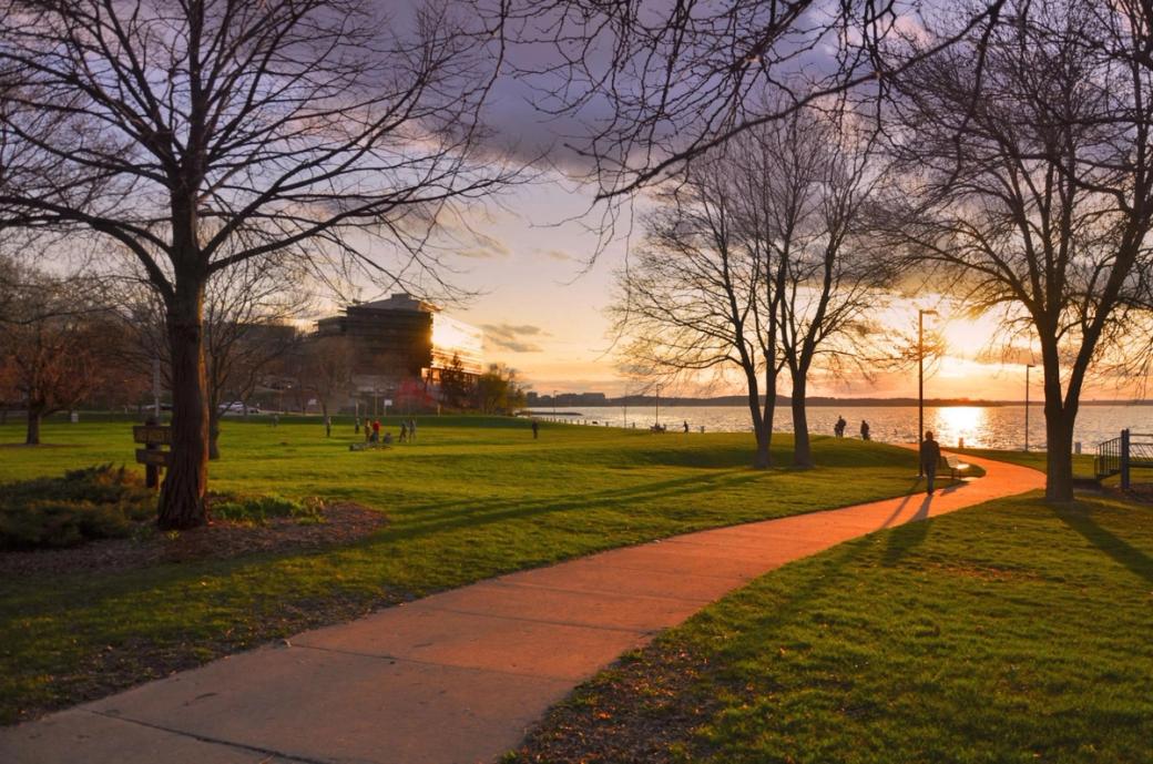 A path extends to the water as the sun sets.