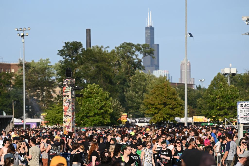 Swarms of people outside at a music fest with the Sears Tower in the distance