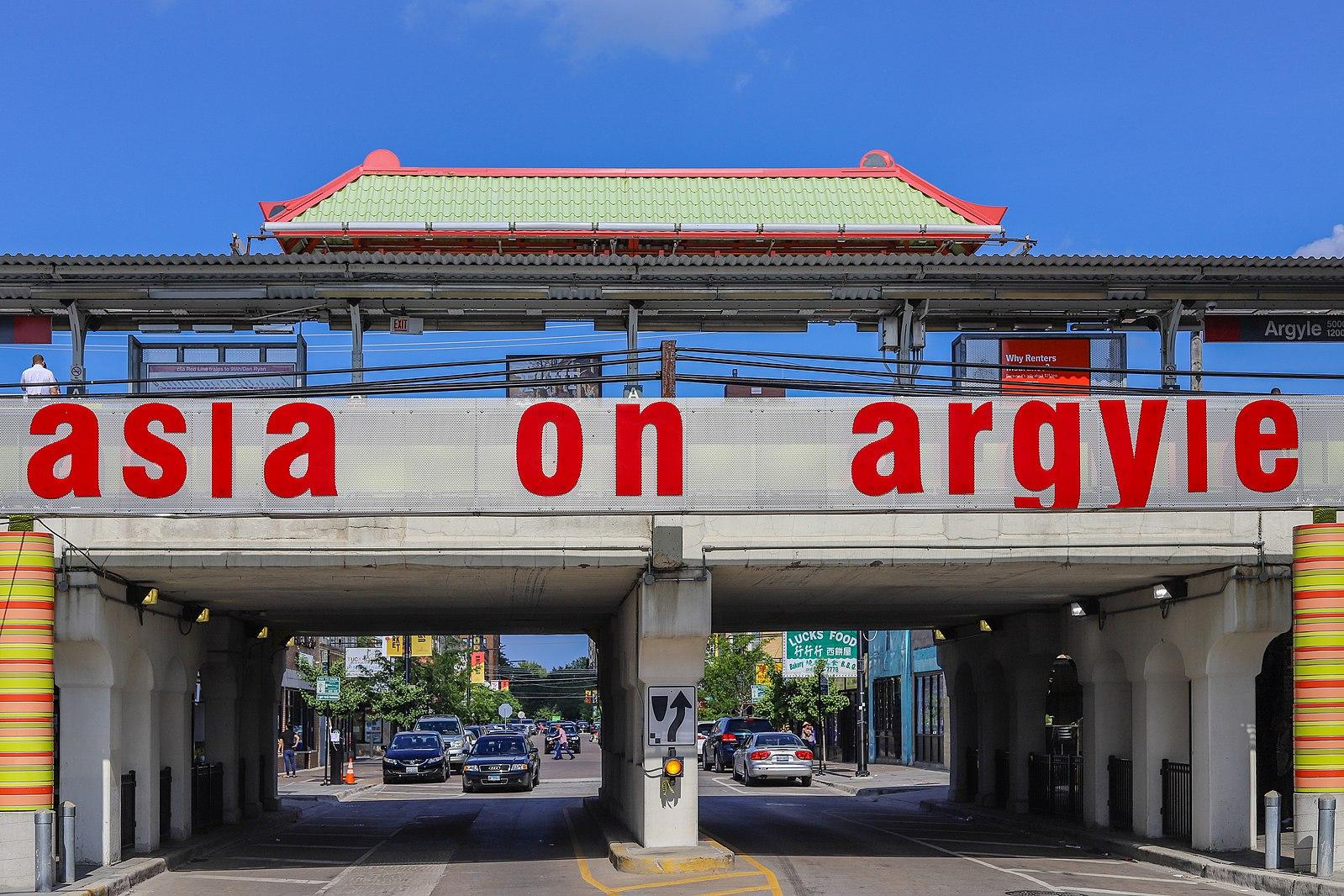 A sign below a train station reads "Asia on Argyle."