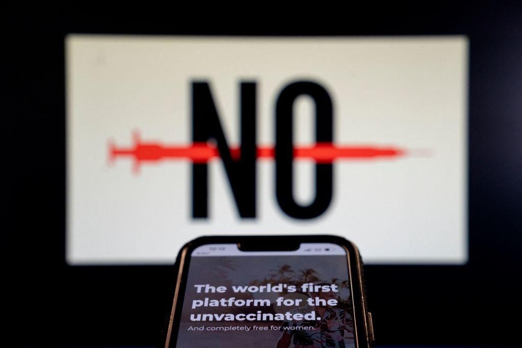 A phone sits in front of the word no with the dating app Unjected on the screen