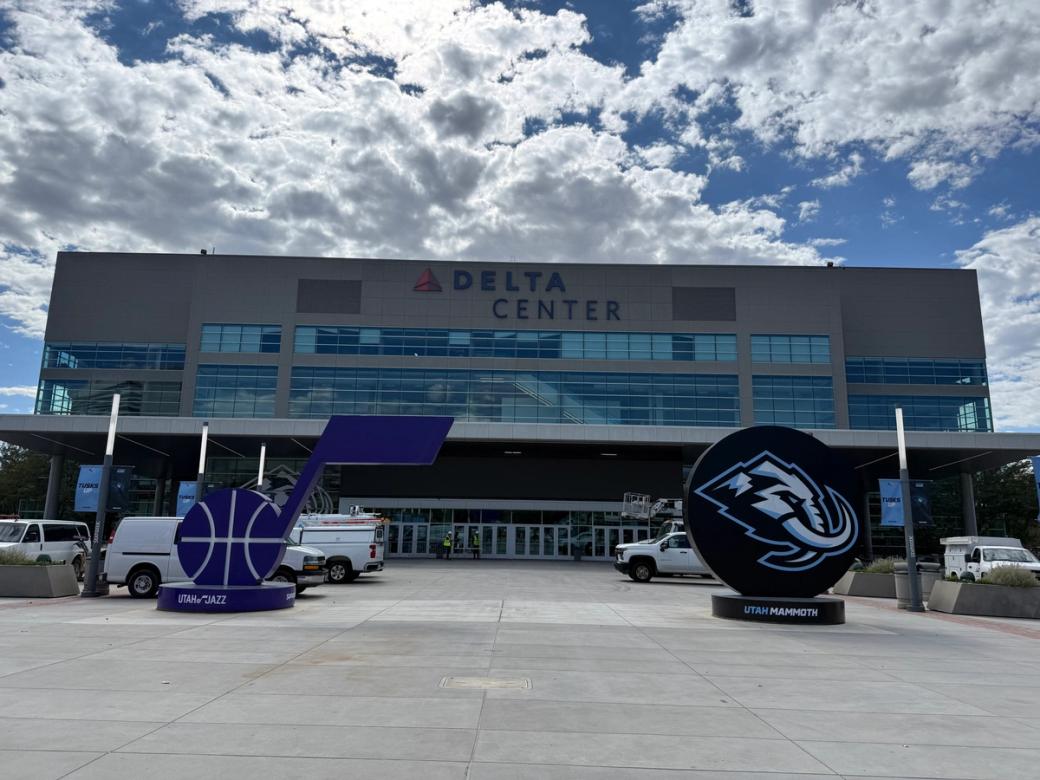  Exterior shot of the Delta Center with Utah Jazz and Utah Mammoth signs in the plaza.