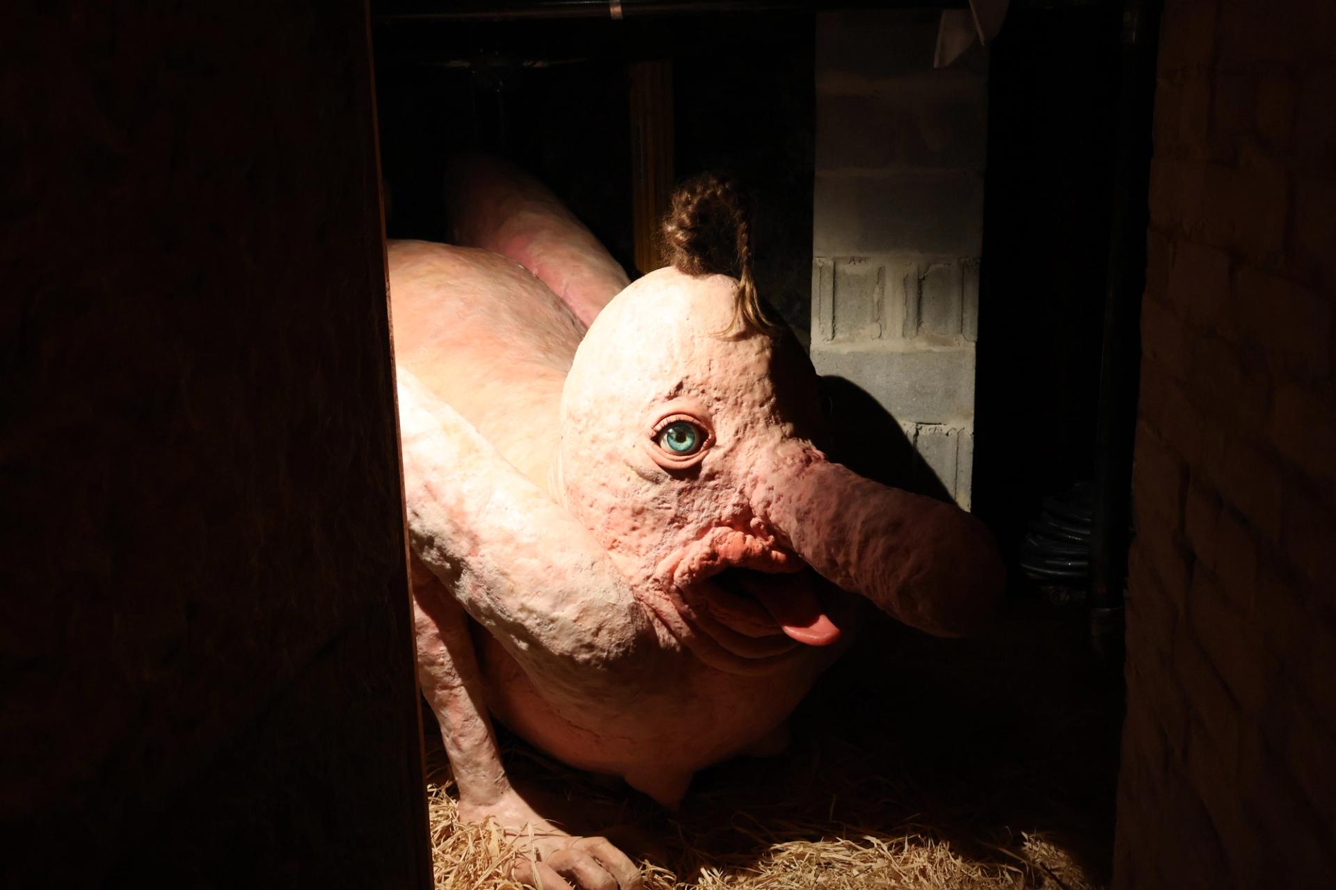 A fantastical creature sitting in a stable-like structure