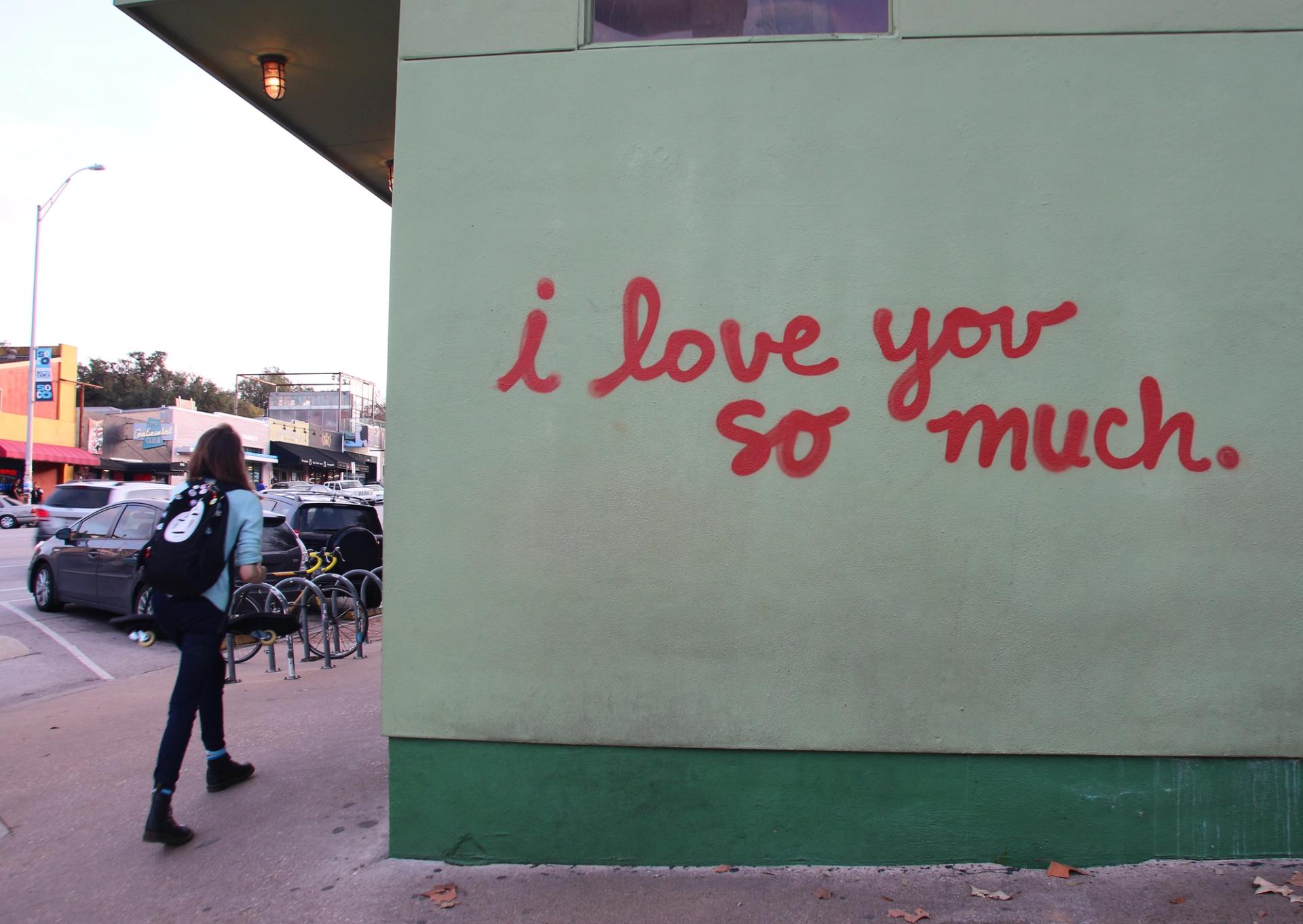 A light green wall with "I love you so much" written on it in red.