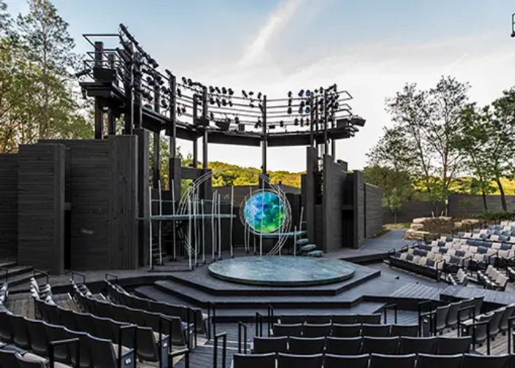 An outdoor stage with a green orb in the middle.