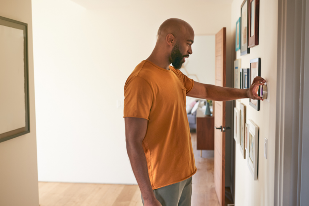 Display ad for MGE; image of person adjusting thermostat