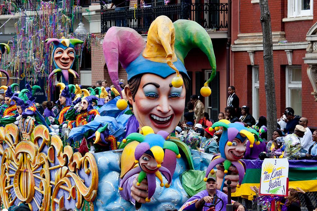 A parade with a giant multicolored jester float.