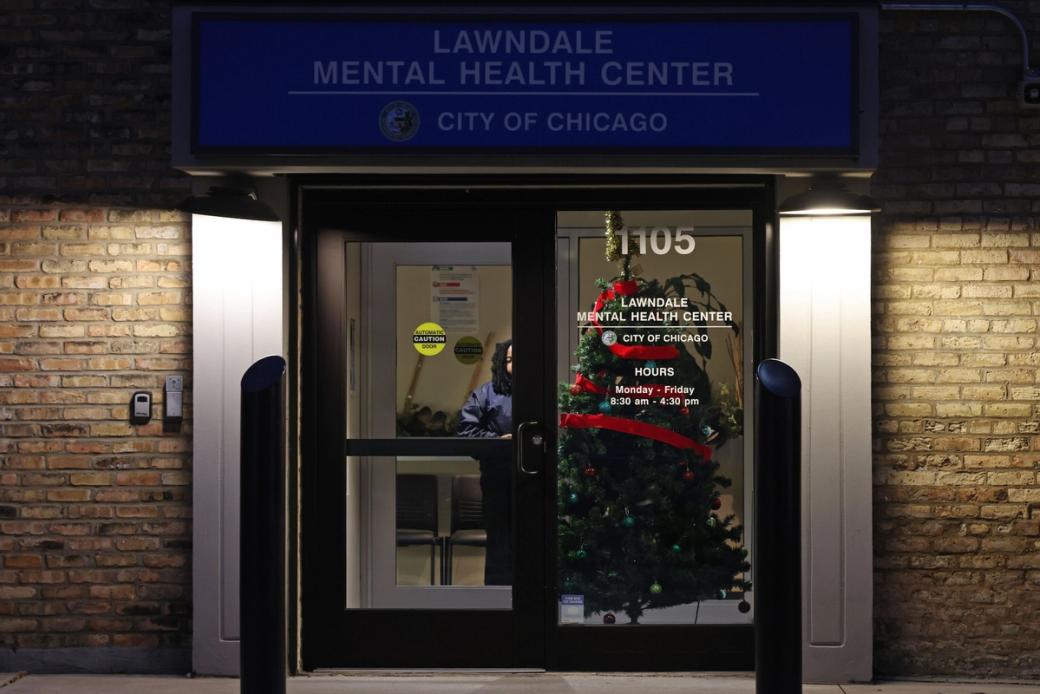 A photo of the doors to a medical facility at night. The sign above the door says "Lawndale Mental Health Center City of Chicago"