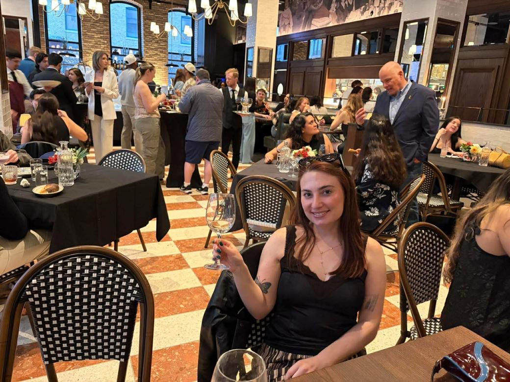 A woman with a glass of wine in a restaurant